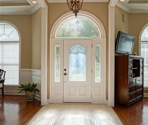 Foyer features a custom Medallion tile inlay and is flanked by the formal dining room and formal study.