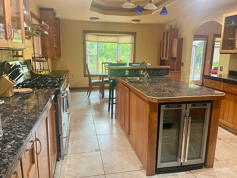 Large shared kitchen with bonus amenities and an excess of storage and counter space. Extra sink and beverage fridge built into the island. Two ovens (one mini and one large). A pot filler above the stove. Dishwasher and large shared fridge.