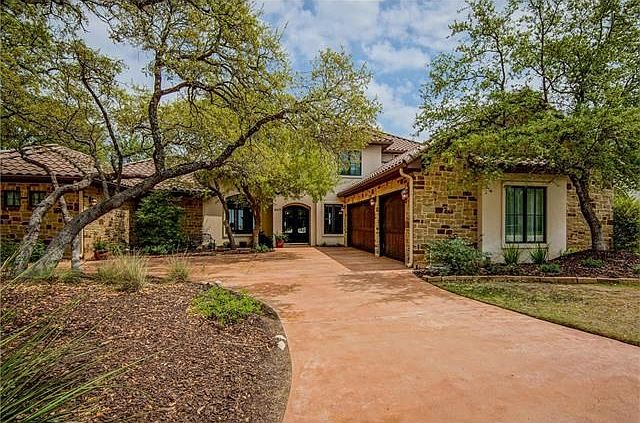 Matt Sitra custom home.  Stone and stucco exterior with tile roof.  Durango entry door with glass inserts that open to let the breeze through. 3 car garage.