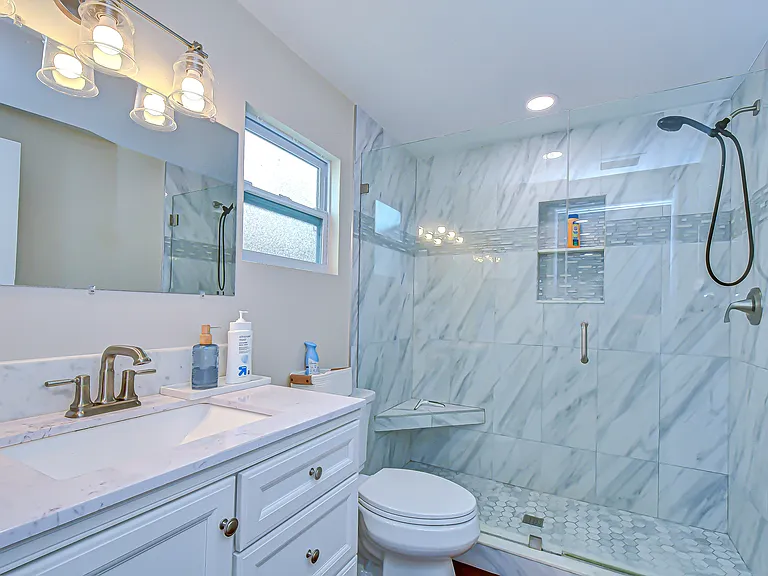 The updated bathroom features a large walk in shower