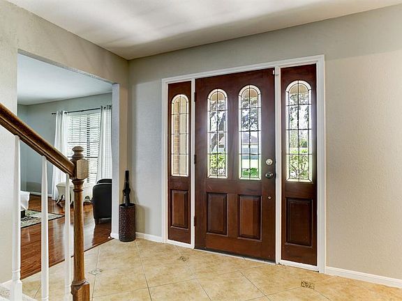 Elegant front door with two side lights adds great natural light and view to living room.