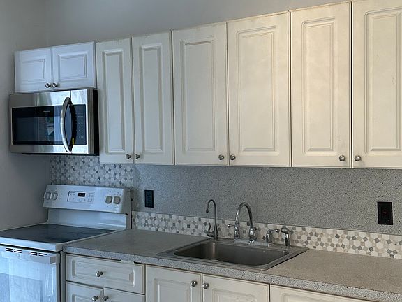 Kitchen with marble backsplash. New range and microwave.