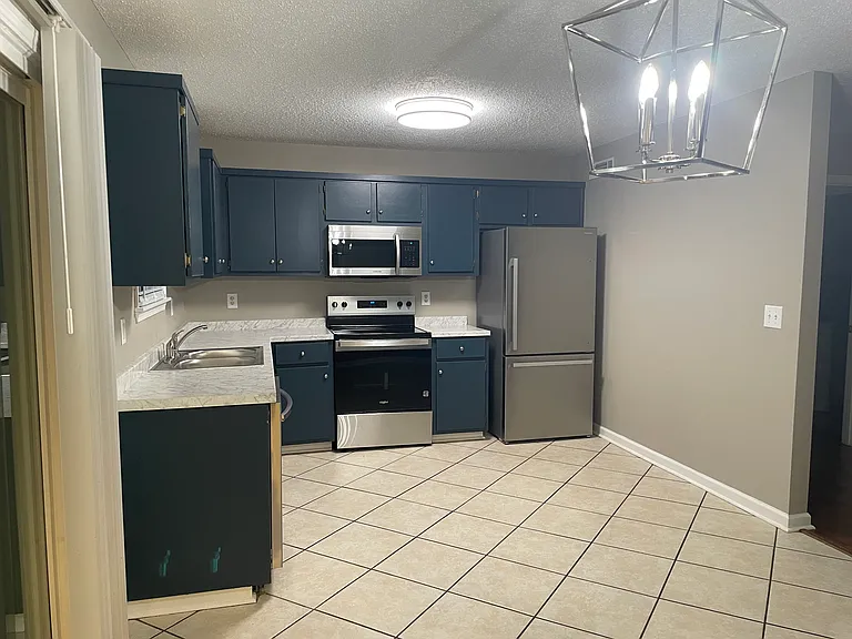 Fully updated modern kitchen with tile floors, stainless appliances, and a lot of cabinet space