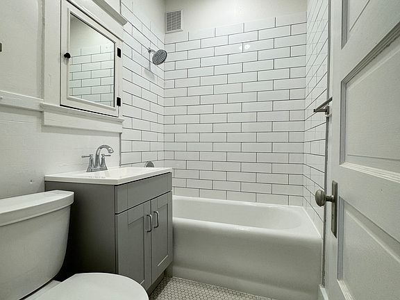 Completely modernized bathroom with new subway tile shower surround, vanity and toilet