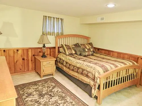Bedroom area with queen sized bed. Includes sheets and bed covering Has a small window.