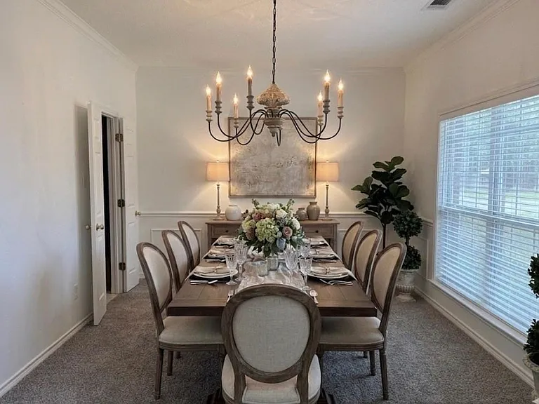 Virtual staging: Formal dining room featuring crown molding, wainscoting, and carpet flooring