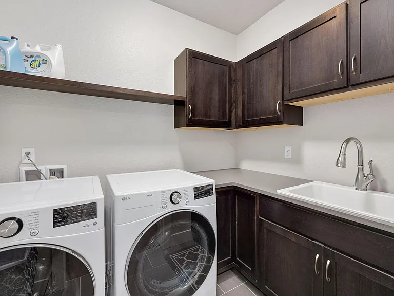 Main level laundry room with new/nice appliances and counter space with sink