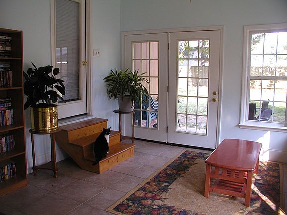 Bright sunroom has a door leading to the master bedroom