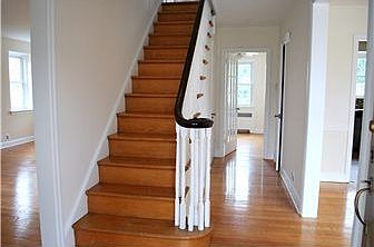 Center hall foyer w/ elegant staircase & wood flrs
