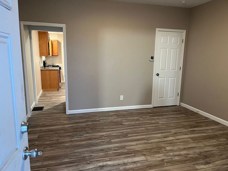 living room with door to closet and basement stairs.
Leads into kitchen..
