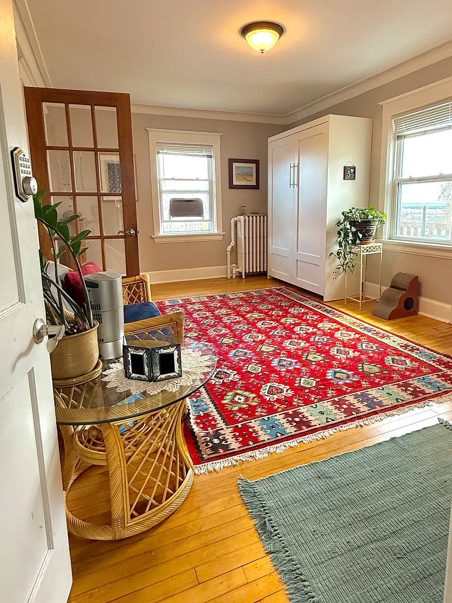 Entrance into living room with full-sized wall bed and french doors. - 612 N 12th Ave E #2