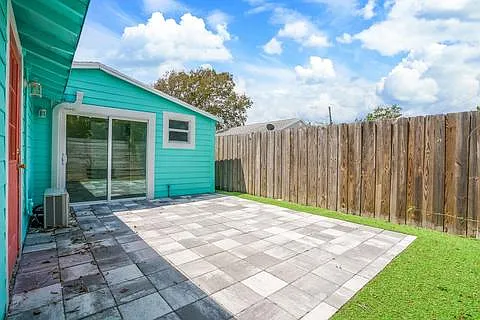 Side rear yard picture, primary bedroom sliding door and bathroom window; door on left is off of kitchen