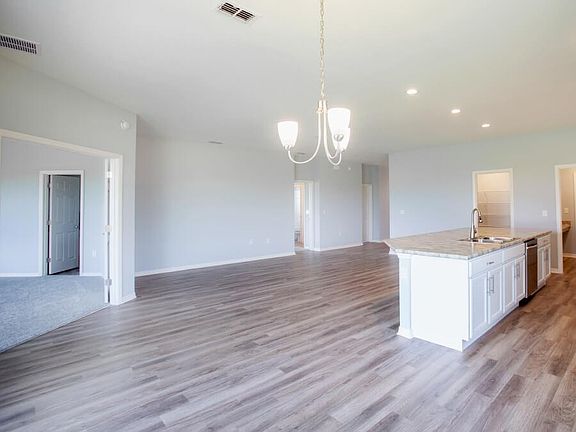 Open living area with luxurious, low-maintenance wood vonyl plank flooring - New home for sale in La