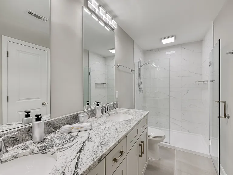 The main bathroom features a spa-like double vanity and a spacious walk-in shower.