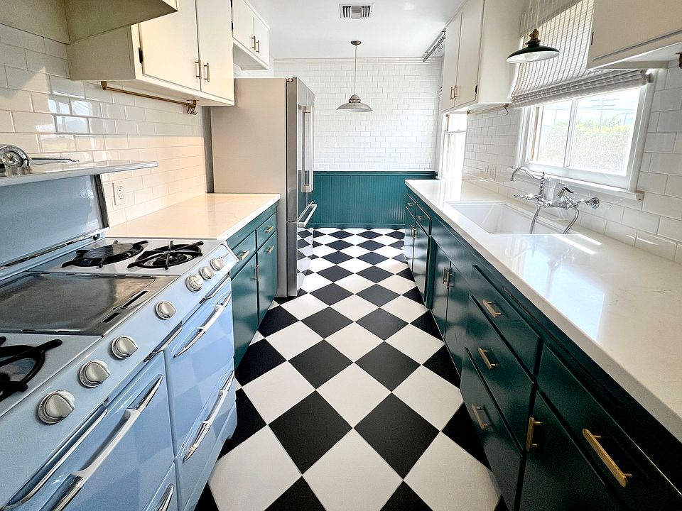 Kitchen as viewed from doorway from dining area. Classic black and white checkerboard floors.