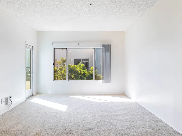 Carpeted Living Room with Balcony