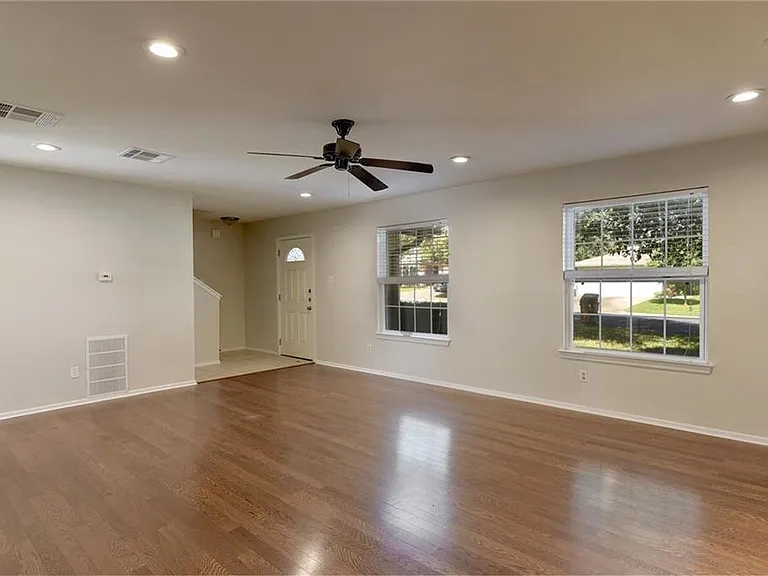 Living room view of front windows, front door and stairs