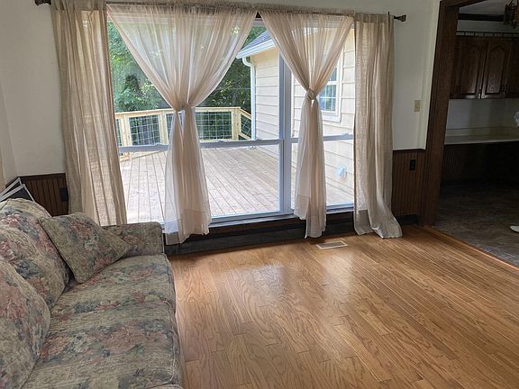Sunroom, for dining or a sitting room, off the kitchen has three walls of windows.