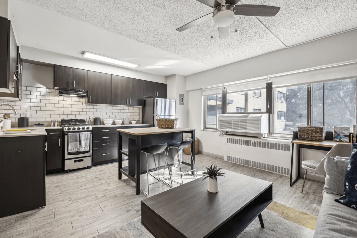 A view of the city can be seen from the large windows that allow light to seep into the living room and kitchen