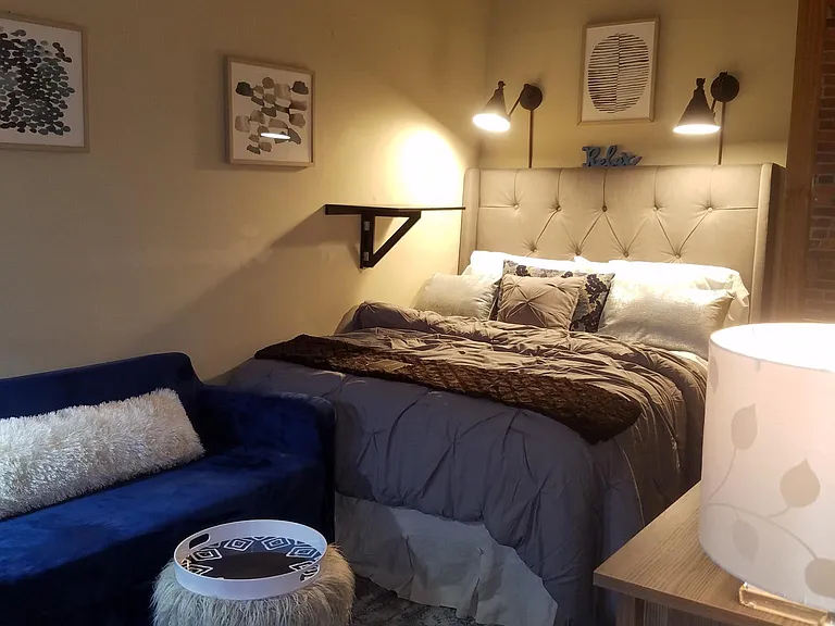 Bedroom #2 with work station/study desk, seating that folds out into a twin bed, TV, dresser, organized closet, full length mirror.
