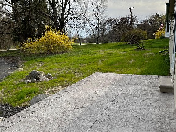 Side of house by living room door. Large stamped patio