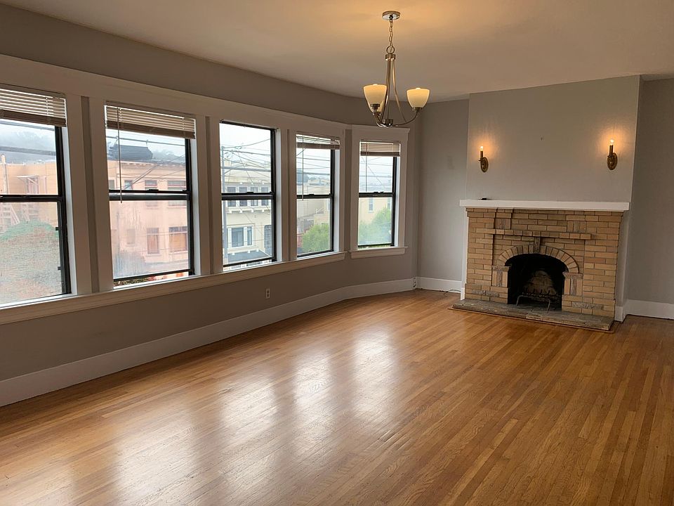 Large living room 24' x 13' with six windows and fireplace
