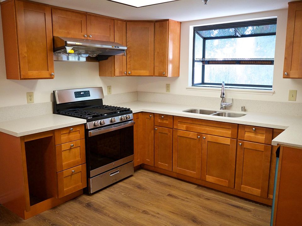 Kitchen with wood cabinets, sink, faucet, quartz countertop, dish washer, hood, range