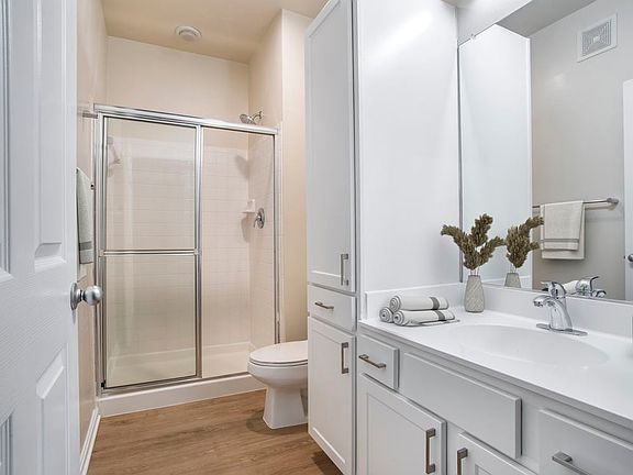 Renovated Package II bath with white countertops, white cabinetry, and hard surface flooring