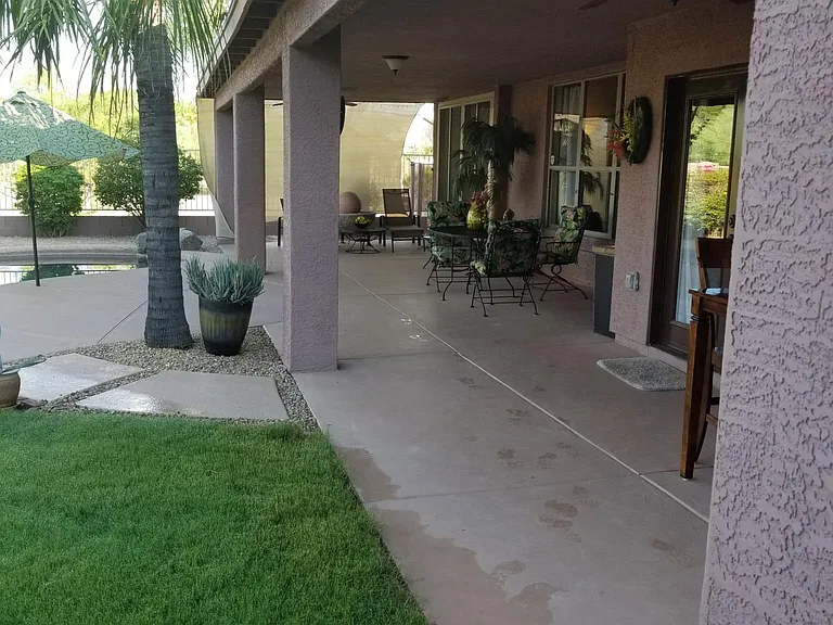 Patio has two dining tables, lounge chairs, water feature, and storage.