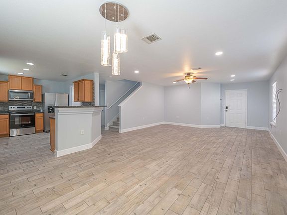Living room, Kitchen and dining area with recessed lights and hard wood floor.