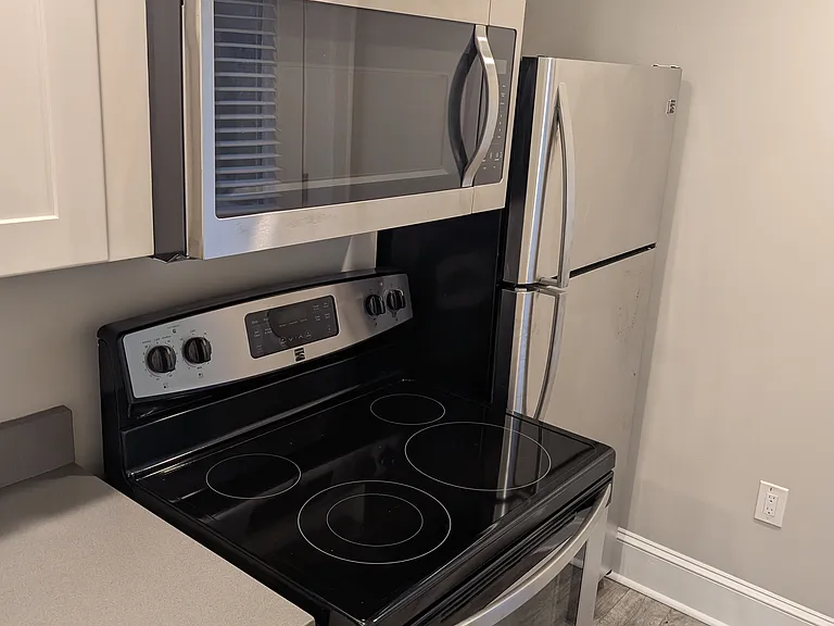 View of microwave, oven, and refrigerator