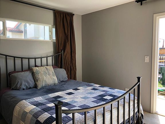 South bedroom: window (faces garden along side walkway), slider (opens to back patio and synthetic grass yard)