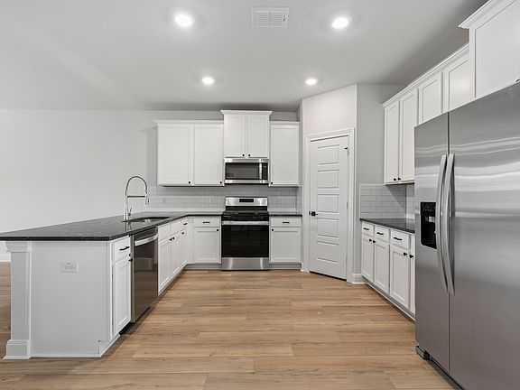 Upgraded kitchen with stainless steel appliances and granite countertops.