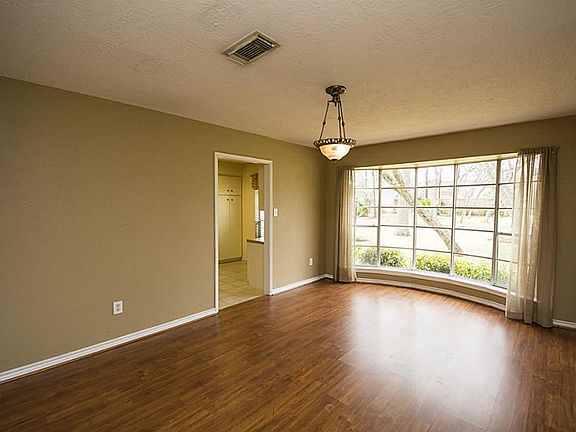 A large formal dining room with huge window with wonderful views of the front yard. Great easy to clean laminate wood floors.