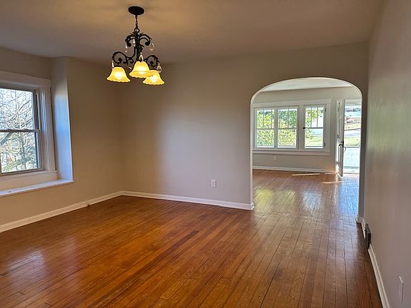Large dining room with built-in bench and windows overlooking trees.