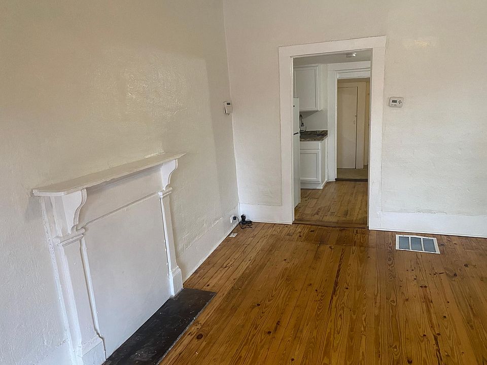Walk into a large living room with original hardwood flooring