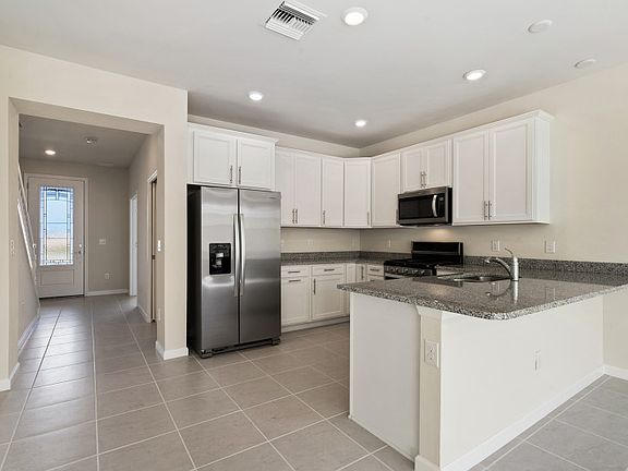 Open kitchen with stainless steel gas appliances and granite countertops