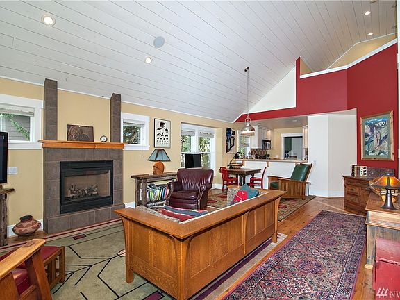 Living room has vaulted ceiling and cozy gas fireplace.
