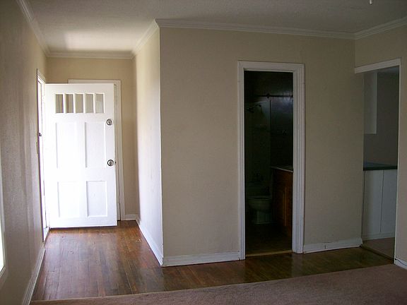 Looking toward Entrance, Bathroom, and Kitchen from Living Room.