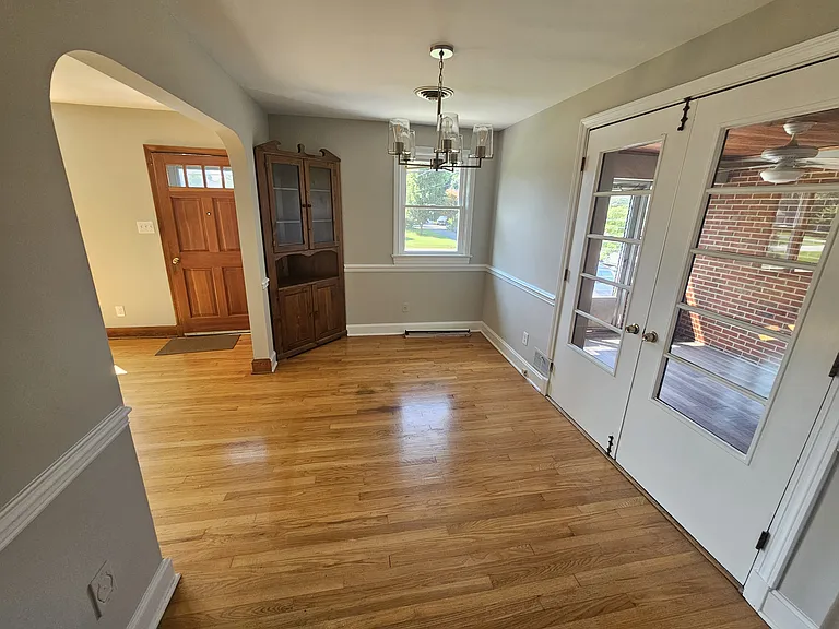 Dining room with refinished wood floors, built in China cabinet and new light fixture.
