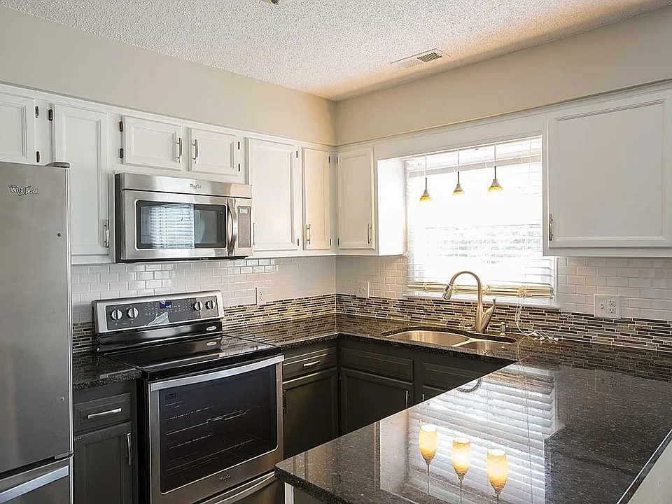 Full suite of Stainless Steel Appliances, Dark granite counter tops, custom tile backsplash