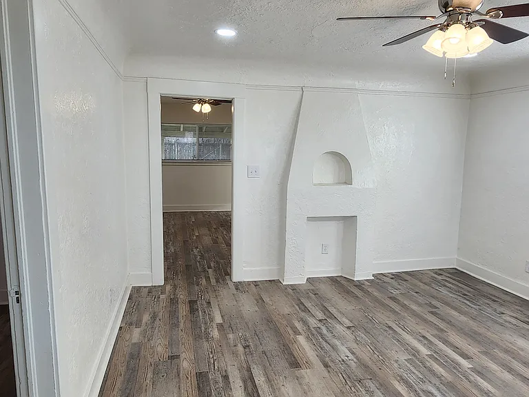 Living room with decorative fireplace feature, ceiling fan and coved ceilings