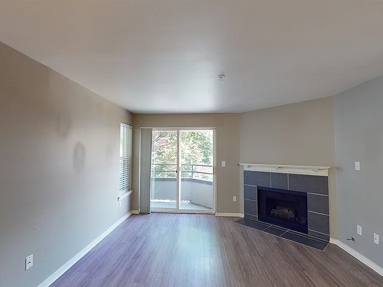 Apartment dining and living room with wood-style flooring and balcony.