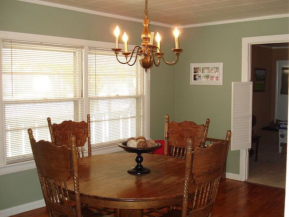 Large dining room with hardwood flooring and crown moulding