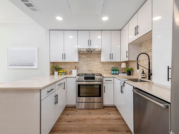Full kitchen view
Contemporary kitchen with quartz countertops, white cabinets, stainless appliances, and tile backsplash_clean, functional, and stylish.