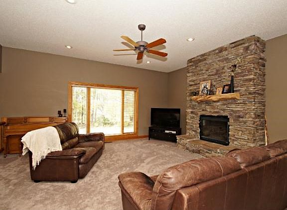 Main level family room with new carpet and a gorgeous stone fireplace with mantel and large picture windows to let in that natural sunlight.