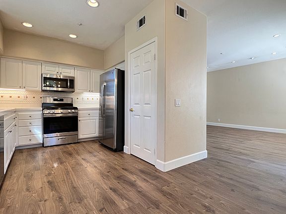 Full stainless steel kitchen with: dishwasher, gas range, microwave, and fridge.