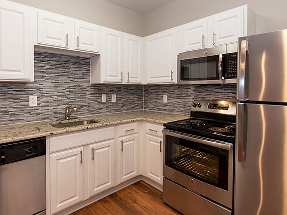 Kitchen with modern cabinetry, stone-style backsplash, and stainless steel appliances