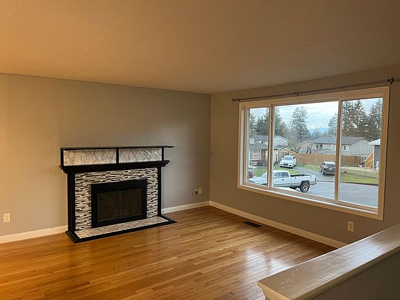 Upper living room with wood burning fireplace and mantle