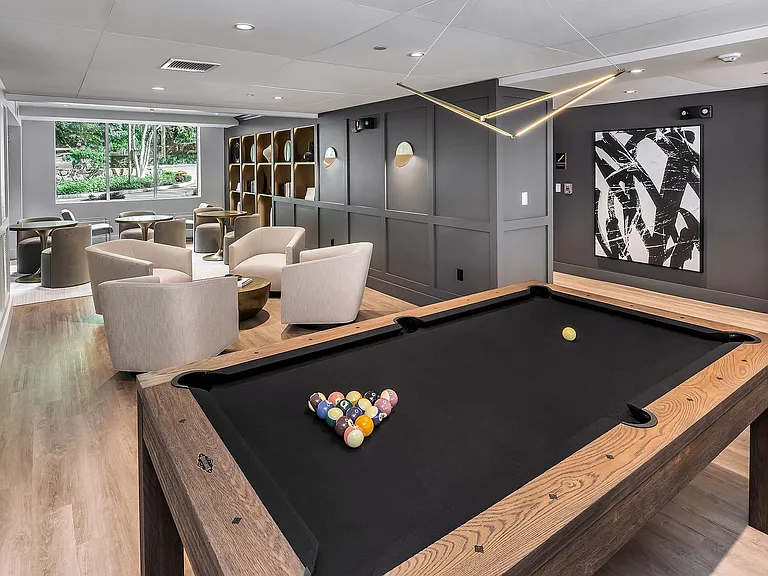 Modern lounge area with a sleek pool table, stylish seating, and contemporary decor for relaxation and entertainment at Parkside Place in Cambridge, MA